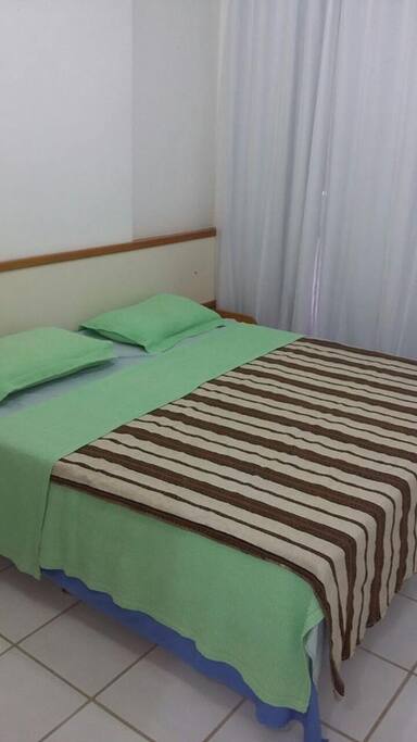 Quarto de casal com armário grande e ar condicionado.