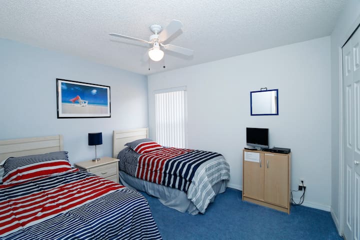 غرفة نوم تضم سريرين صغيرين