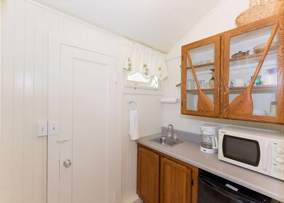 Cozy kitchenette with microwave and fridge.