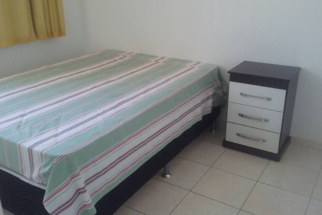 Quarto com cama de casal e cortina com black out