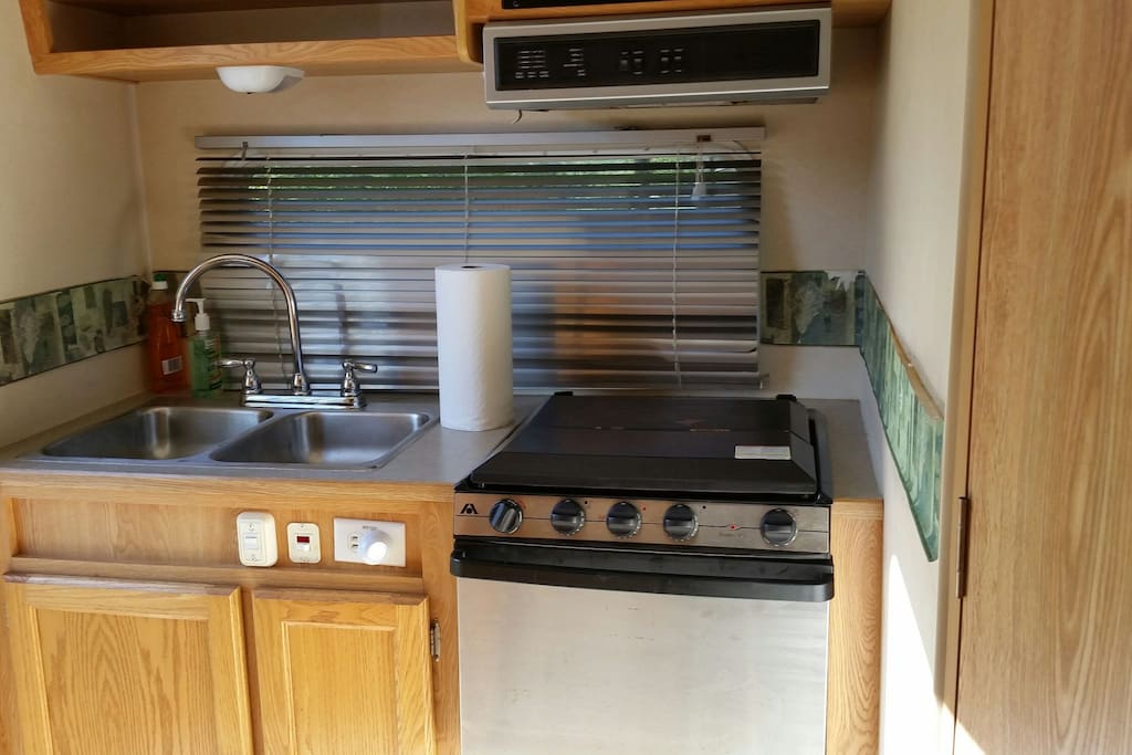 fully equipped kitchen with mirco, refrig, coffee pot, toaster, pots, pans, and 3 burner range with oven