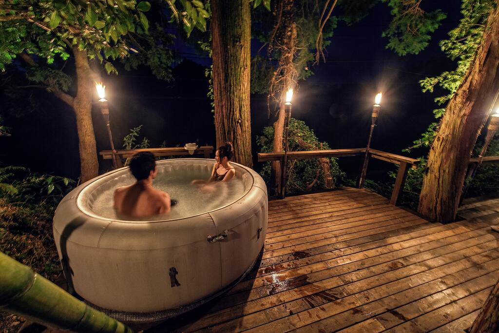 Guests enjoying the jacuzzi and torch-lit back deck