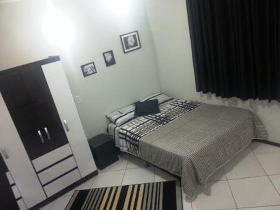 Cama de casal, roupeiro e janela para o corredor