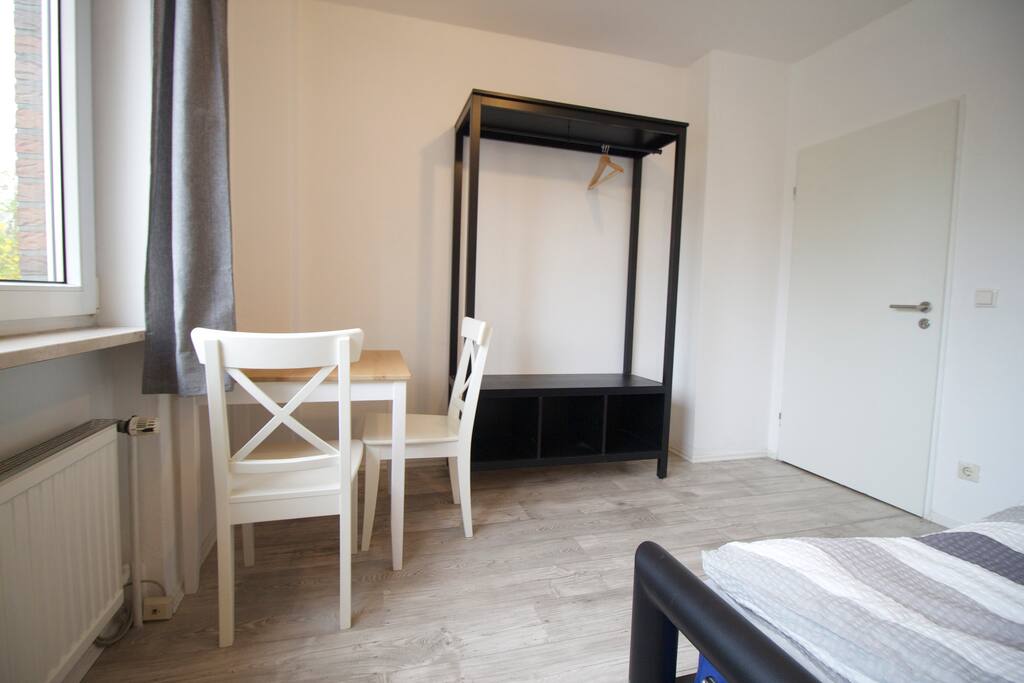 Zimmer mit Doppelbett, Tisch und Stühlen und Kleiderschrank