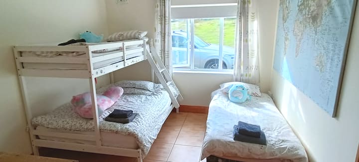 Habitación luminosa y espaciosa con litera doble y cama doble. 