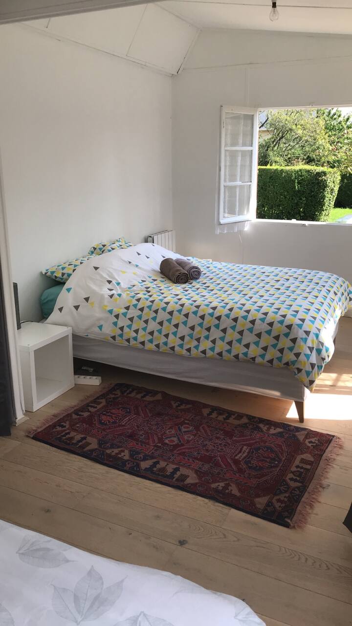 חדר שינה שני עם מיטה זוגית
חלונות חדר שינה המשקיפים על הגינה