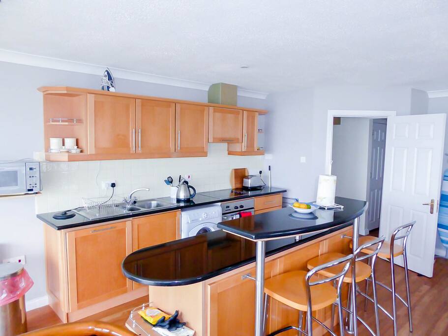 Kitchen with dishwasher, oven and hob, kettle, microwave, toaster, fridge and freezer.