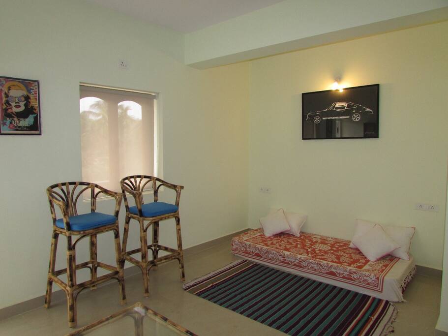 Main hall with mix earthy comforts of cane furniture and american legends on the wall along with wine & book rack