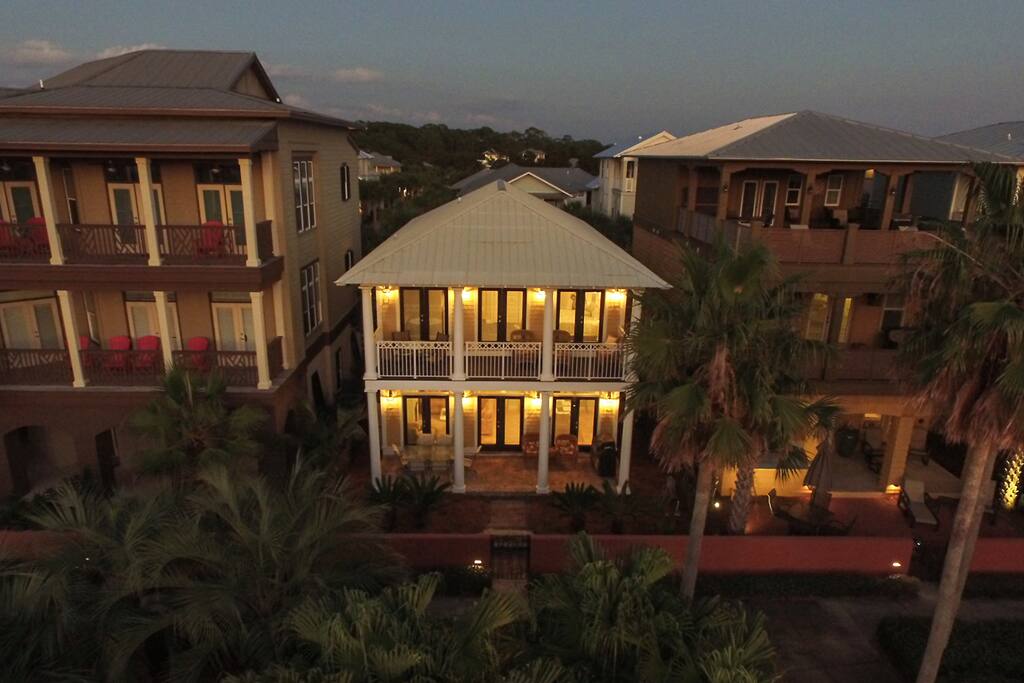 Second floor balcony and first floor patio span the width of the home and overlook the Seacrest Beach green space and pool