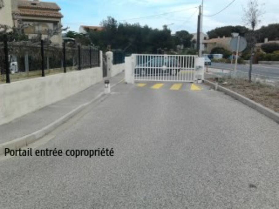 Entrée de la copropriété, portail sécurisé et place de parking