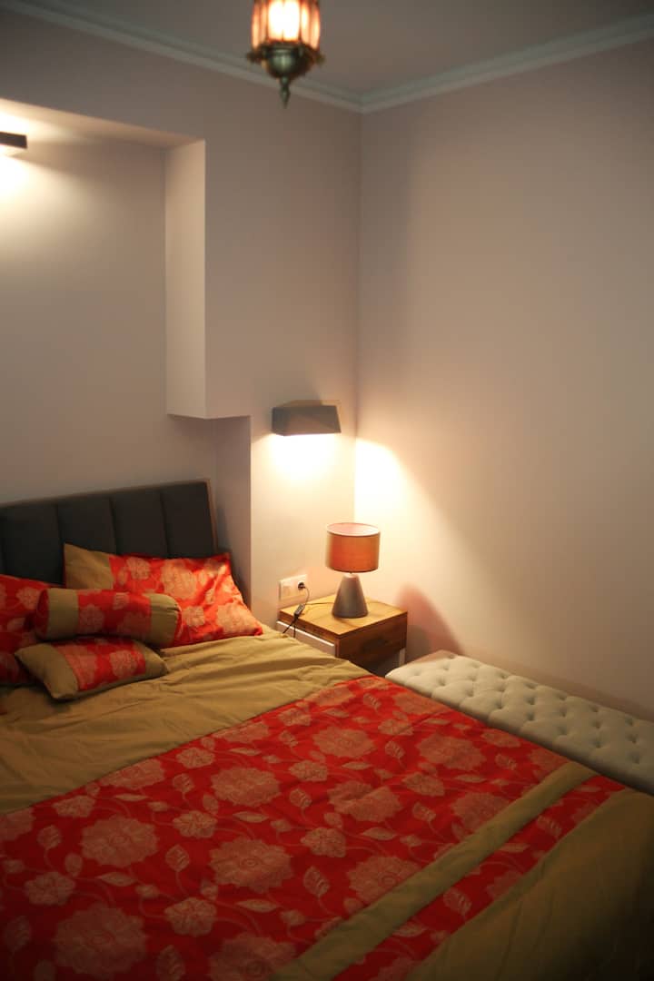 ליד המיטה שמיכות ובגדים מתקפלים.