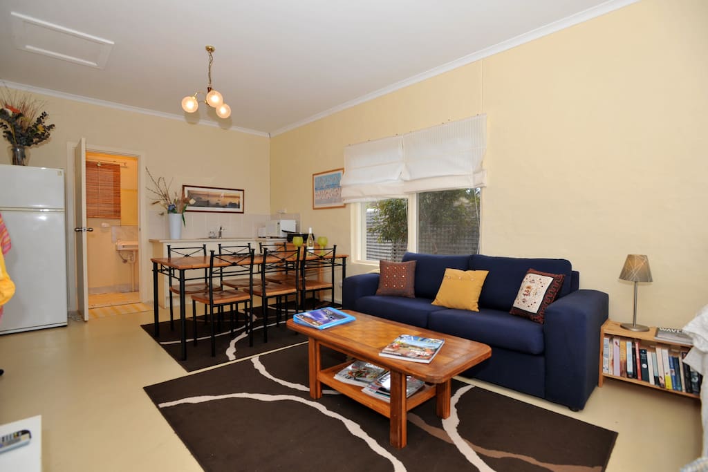 Comfy sofa with dining area, kitchenette and bathroom behind