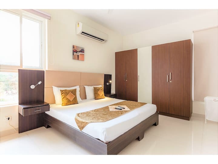 Designer Bed with premium mattress, spacious Wardrobe, noiseless Split AC, Work Desk & Flat screen TV showing Tata Sky with international channels