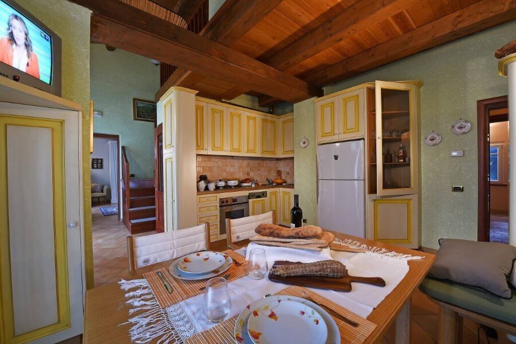 In questa foto si vede il soggiorno e la zona cucina completa di lavastoviglie , machina per il caffe forno ventilato , fuochi e ampio frigo frizzer , accessibilità sul balcone da 2 grandi porte finestre con ampia vista sul parco e sulla parte storica di Mondovì