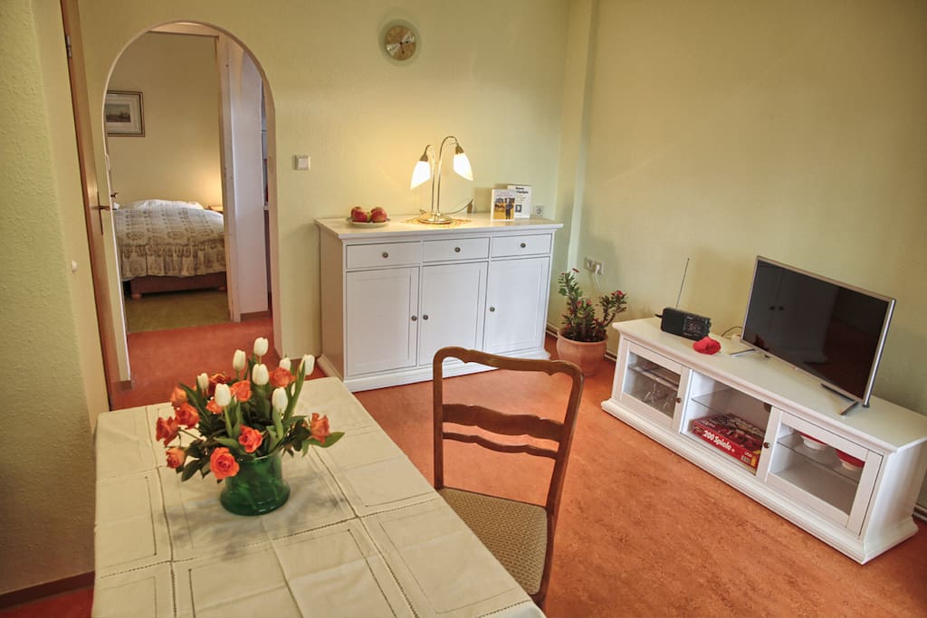 Wohnzimmer mit Schlafcouch und Esstisch