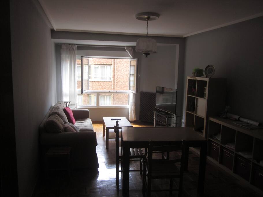 Salón con sofá, mesa de estudio/trabajo y televisión 42 pulgadas.