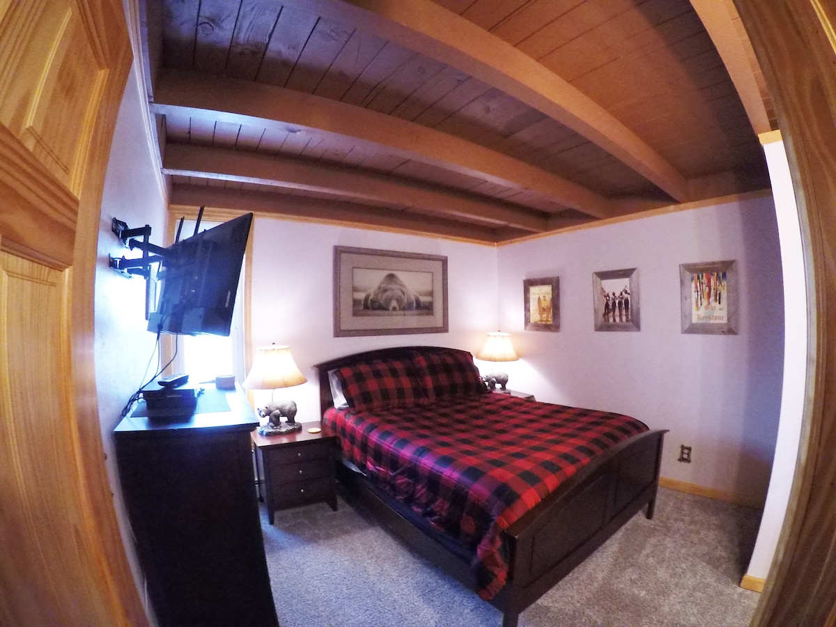 Gezellige hoofdslaapkamer met een queensize bed, smart-tv, kabel, blu-ray-speler en een eigen badkamer.