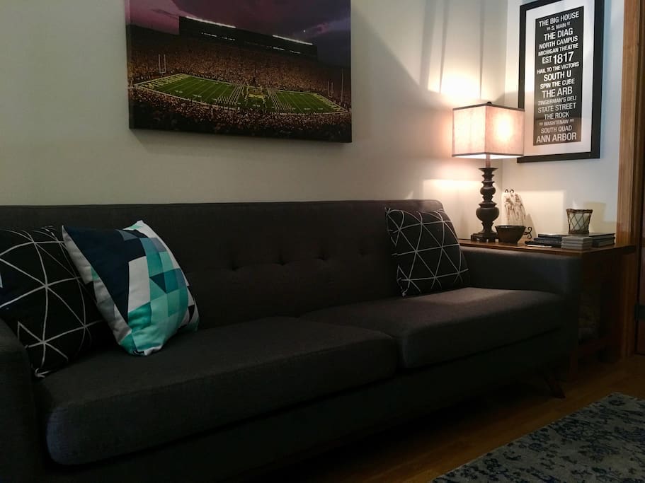 A large couch with accent pillows can sit four comfortable.