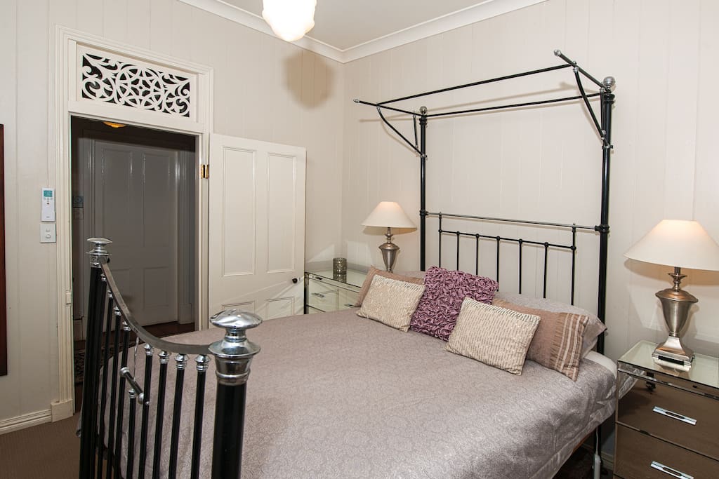 Queen size cast iron and nickel antique bed in master bedroom