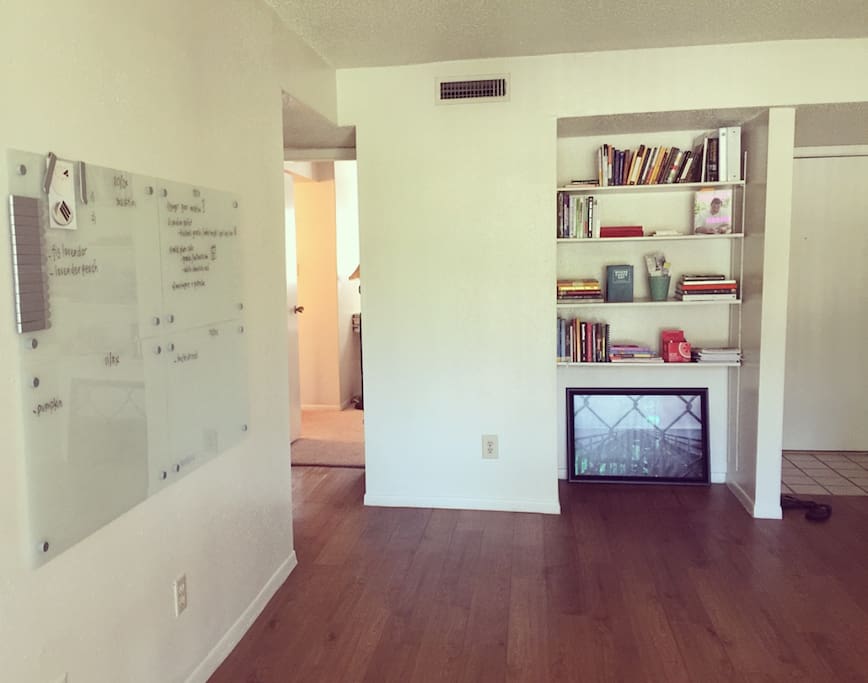 spacious living space with book shelf filled with inspiring books and dry erase 'creative' board