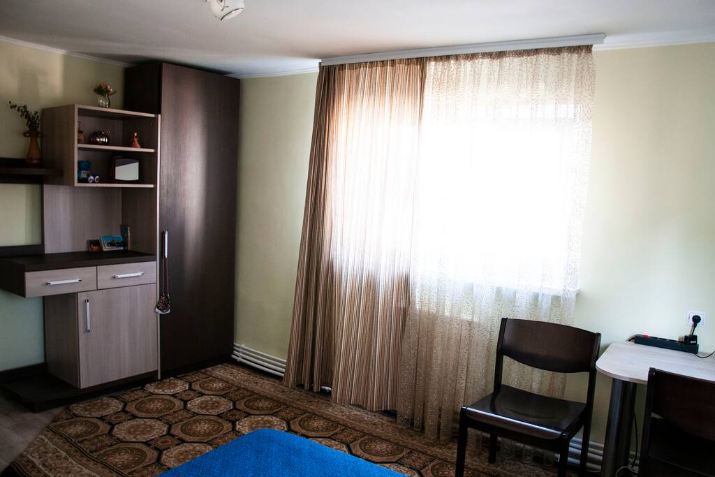Main bedroom with queen size bed, closet, desk and chairs.