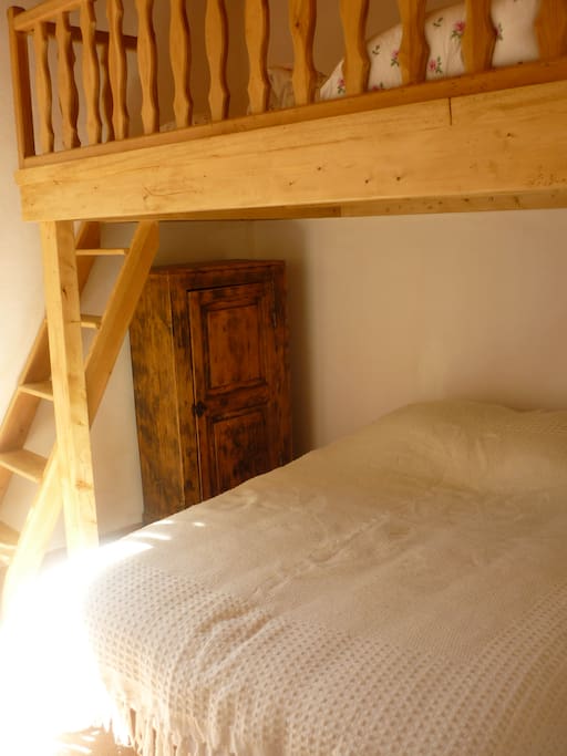 Chambre avec un lit double sous la mezzanine et 2 matelas simples au-dessus