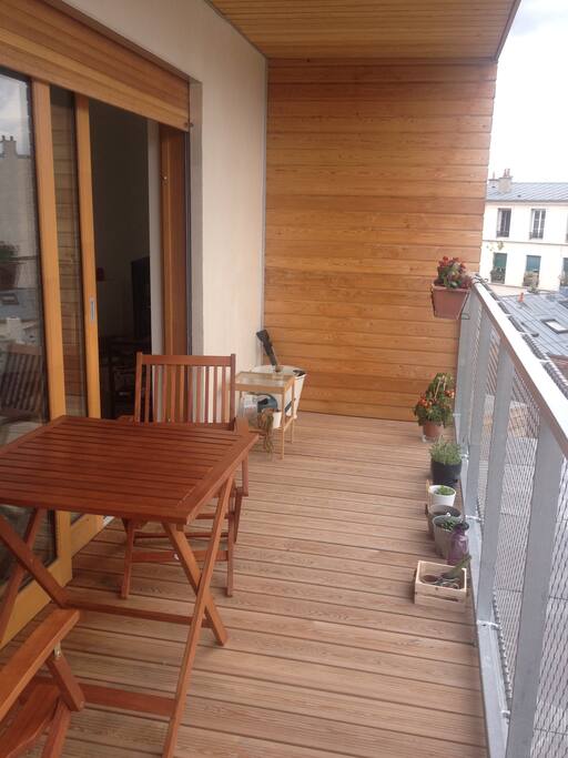Grand balcon avec une table et deeux chaises