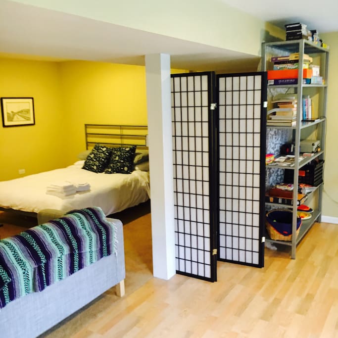 Comfortable queen bed in private space equipped with TV, games, turntable and records.