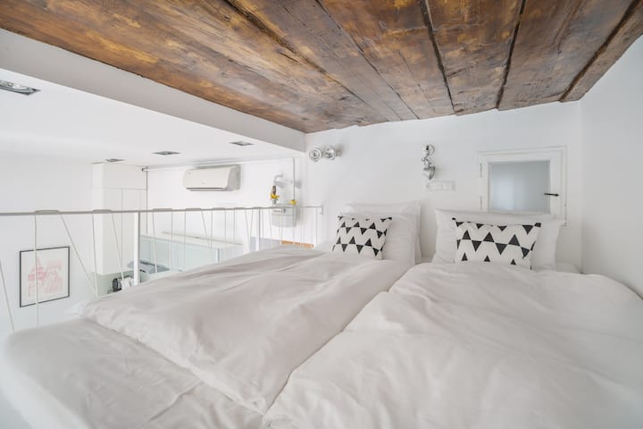 Bed on the gallery with rustic ceiling creates tomantic atmosphere.