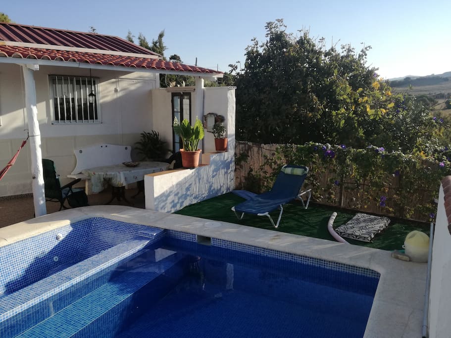 vista frontal de la casa en la que aparece piscina con yacuzzi y solarium