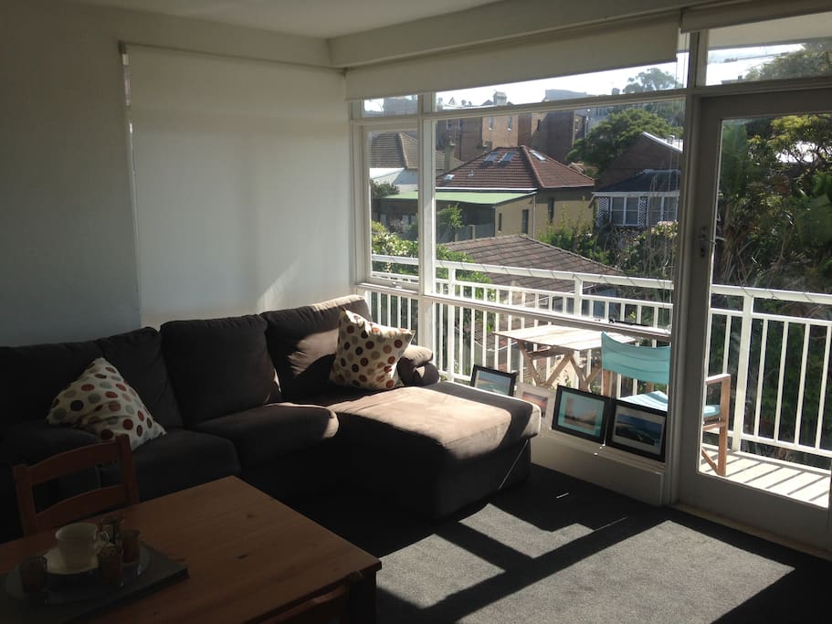 Lounge room (part blinds drawn because it was TOO sunny for the photo!). Leads out to wrap-around balcony. Dining table and chairs, and a TV & DVD player available