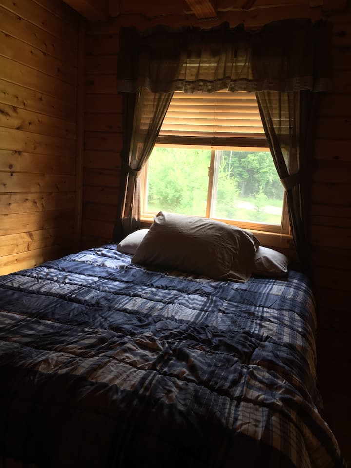 Queen size bed in first bedroom downstairs.