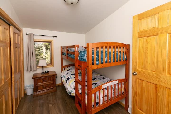 Twin bunkbeds with twin floor mattress, nightstand and closet.