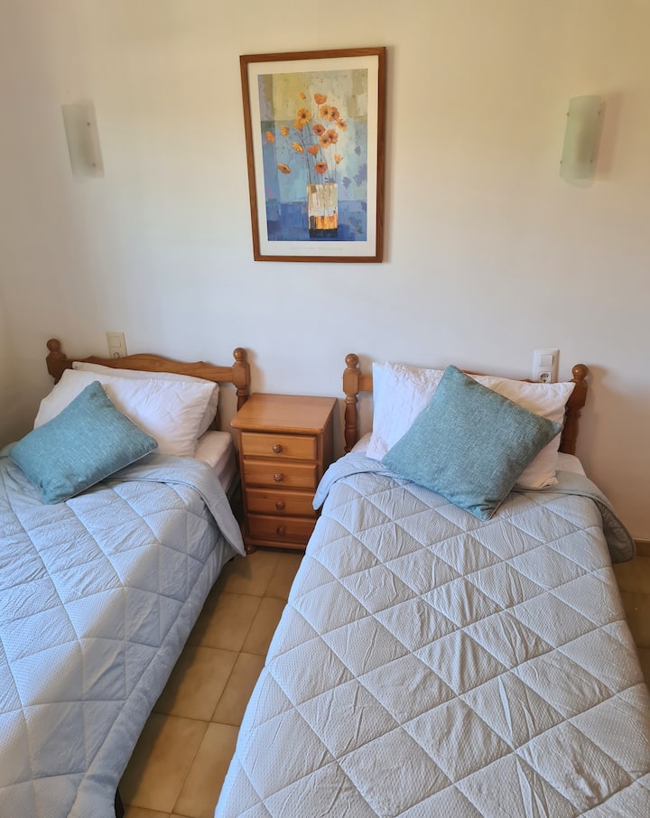 Twin bedroom, with air-conditioning, ceiling fan, fitted wardrobes and views over the garden.
