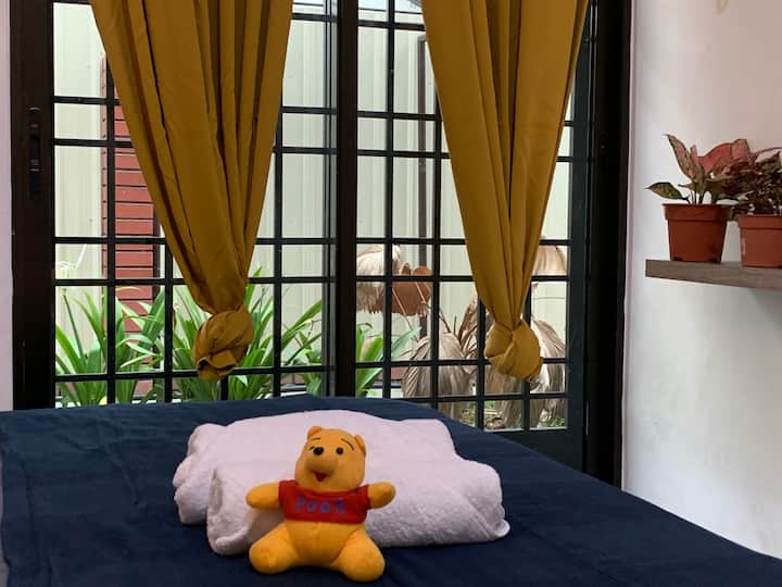 חדר זוגי מפואר עם חצר צדדית שופעת צמחייה. מצויד במראות, שולחן איפור וכיסא. 