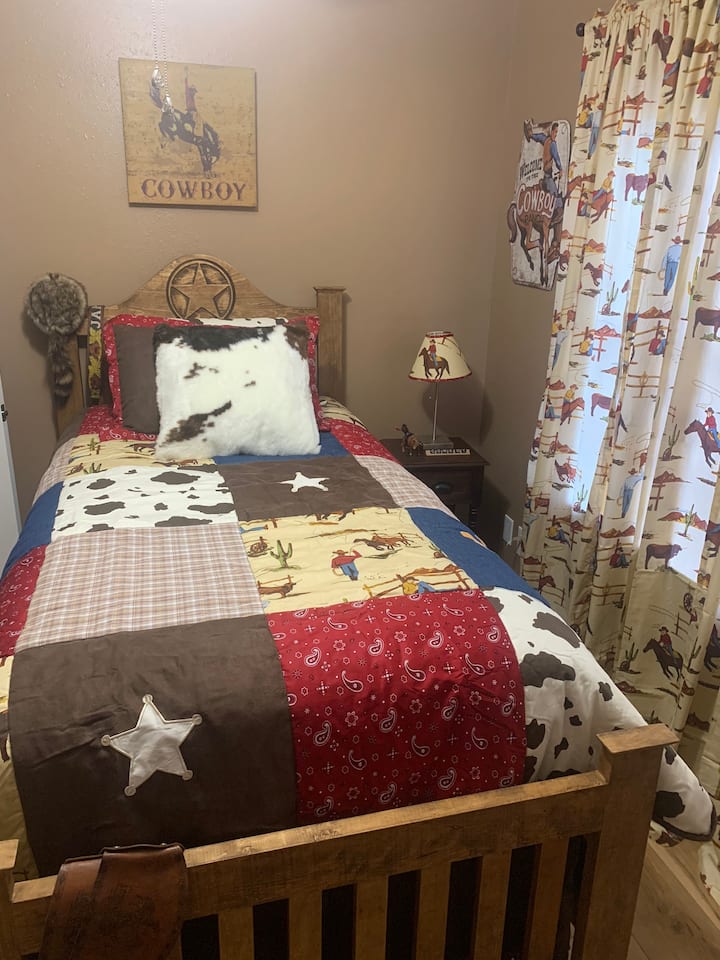 Our cowboy room has a single bed and toys. 
