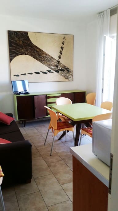 zona giorno con arredi vintage e quadri contemporanei