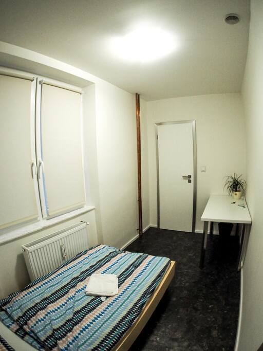 Bed is 90 cm wide. You can find also table with chair in your room.