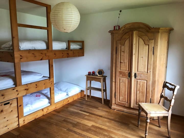 Chambre avec lits superposés et armoire ancienne