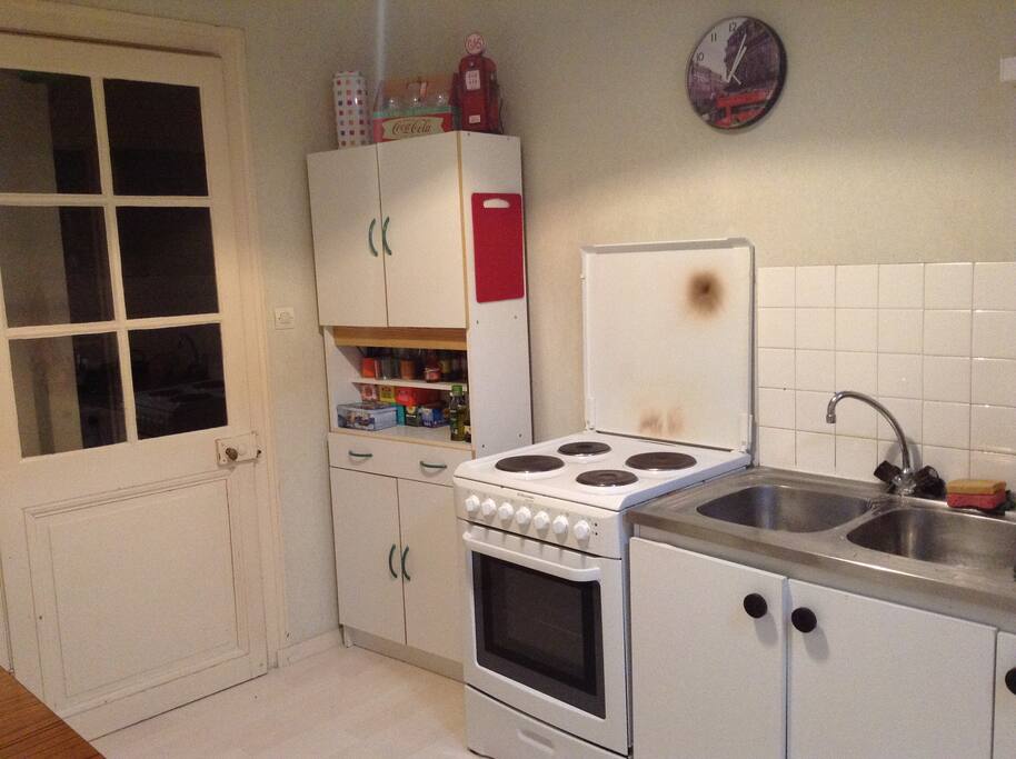 Coin cuisine avec four, plaque de cuisson, et vaisselle à disposition
