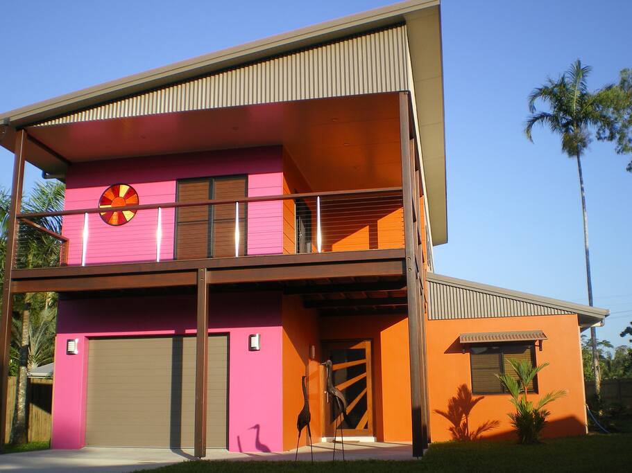 View of front of tropical home from cul-de-sac; lock up garage