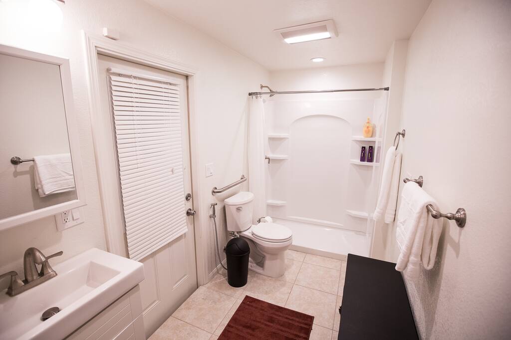 Bathroom area is spacious and well-equipped with towels and other necessities.