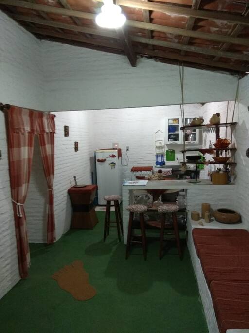 Cozinha e sala com sofá.