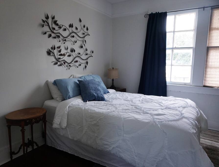 Comfy queen size bed with fluffy pillows and convenient electric outlets next to each nightstand for cell phone charging.