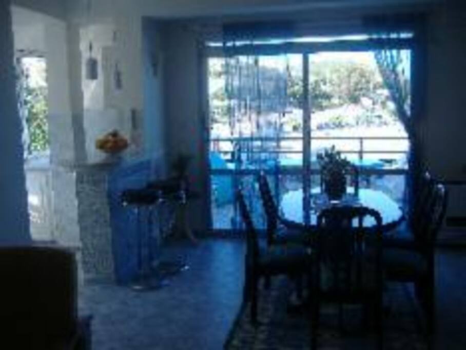 Salle à manger qui communique avec le salon et la cuisine et qui donne sur la terrasse