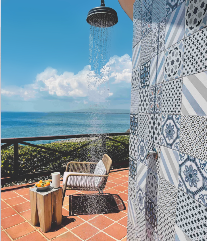 A seaside apartment in Palermo. Artisanally-crafted blue tiles line the outdoor shower overlooking the ocean of this gorgeous shorefront home in the heart of Italy.