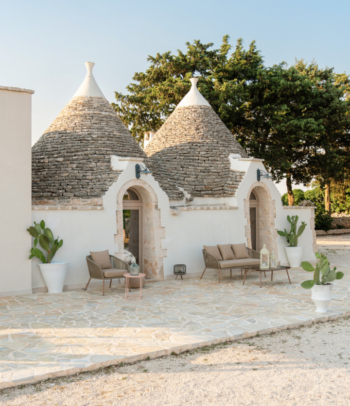 Poolside trullos with a garden view in Ostuni, Italy. Rustic and charming in their own way, these domed, smooth white structures are both inviting and awe-inspiring due to their storied history and culture.