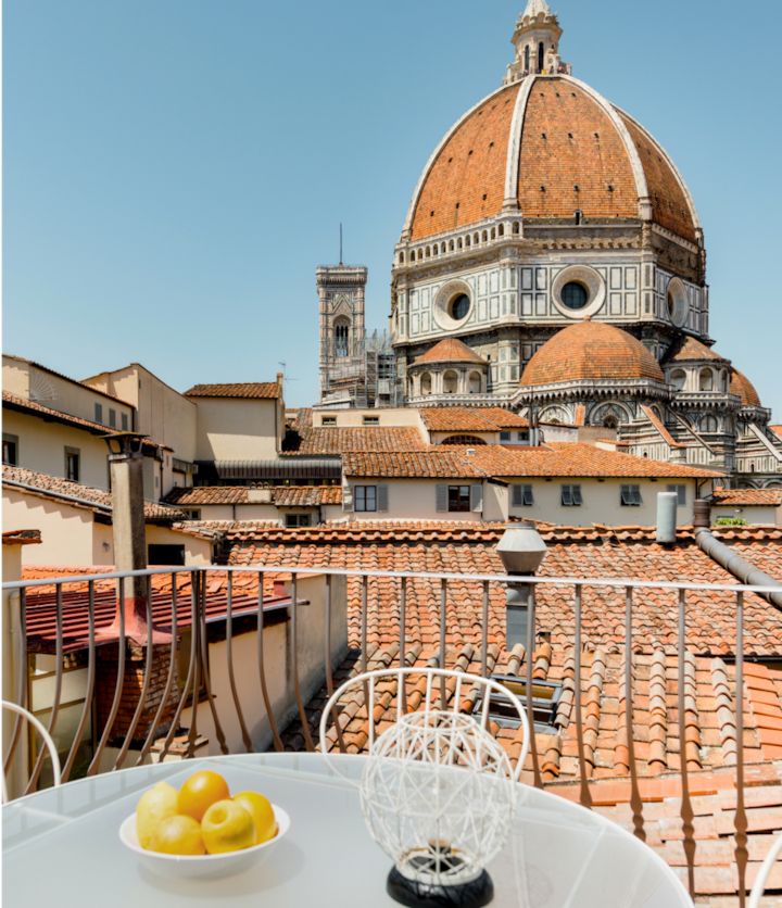 Un appartement historique au cœur de la ville de Florence. Depuis la véranda extérieure, la couleur terracotta des toits de la ville contraste avec le ciel bleu de cette ville italienne.