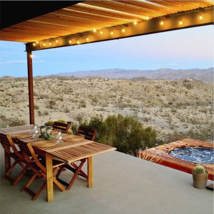 The patio of a home in Yucca Valley, looking out over a jacuzzi and desert landscape.  