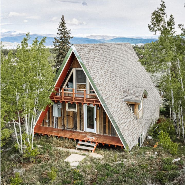 An A-frame cabin in the woods.